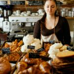 Frau in einer Bäckerei. Sie verdient kaum mehr als Arbeitslose. Foto: Unsplash/ Ekaterina Tyapkina