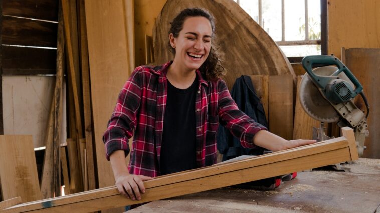 Arbeitslosengeld Burgenland man sieht eine Frau mit einem Holzpflock in der Hand in einer Werkstatt