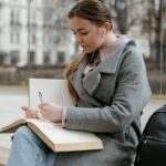 Gleichstellung Gemeinden Österreich Frau sitzt auf einer Bank und liest ein Buch