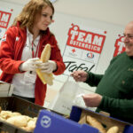Eine Helferin der "Team Österreich Tafel" verteilt Lebensmittel. Bild: ÖRK/Nadja Meister