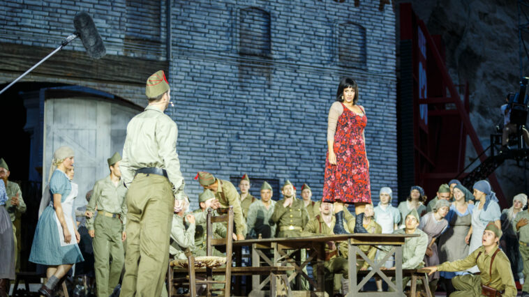 Solistin, umringt von Statisten und Statistinnen in der Oper im Steinbruch