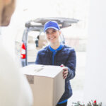 Eine Paketzustellerin liefert ein Paket aus. Ab Jänner bekommt sie um 16 Prozent höheres Gehalt.