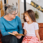 Ältere Frau mit Kind beim Vorlesen, Volksschule, Lesepate Burgenland