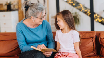 Ältere Frau mit Kind beim Vorlesen, Volksschule, Lesepate Burgenland
