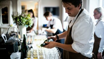 Kurz Martin Ho The Dots Group Lohnbetrug Kellner gießt Champagner in Gläser