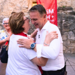 Andreas Babler umarmt auf der Herz und Hirn Tour in Perchtoldsdorf eine ältere Dame.