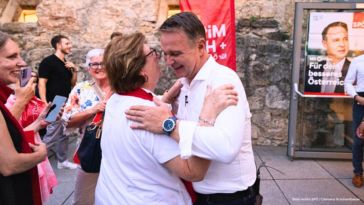 Andreas Babler umarmt auf der Herz und Hirn Tour in Perchtoldsdorf eine ältere Dame.
