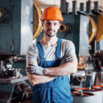 Ein Fabrikarbeiter steht mit verschränkten Armen vor einer Werkzeugbank. Peter Kaiser schreibt in seinem Gastkommentar über den Leistungsbegriff.