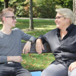 Die Bürgermeisterin von Schwechat, Karin Baier, plaidert auf einer Bank im Park mit einem Bürger.