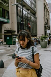 Junge Frau mit Handy in einer Großstadt