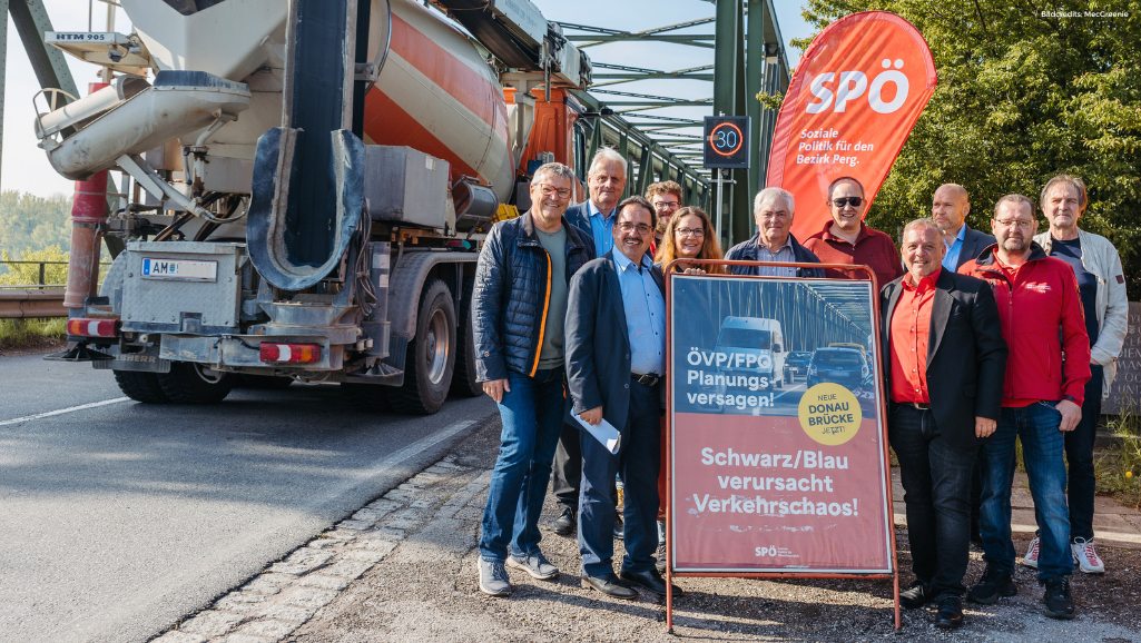Kommunalpolitiker:innen demonstrieren vor der Donaubrücke Mauthausen