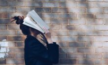 Verzweifelte Person hält sich ein Buch vors Gesicht Bildungskarenz